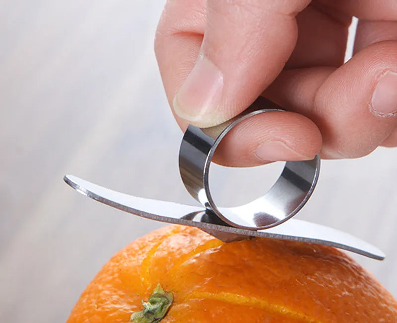 Silver stainless steel ring peeler for citrus fruits on a white background