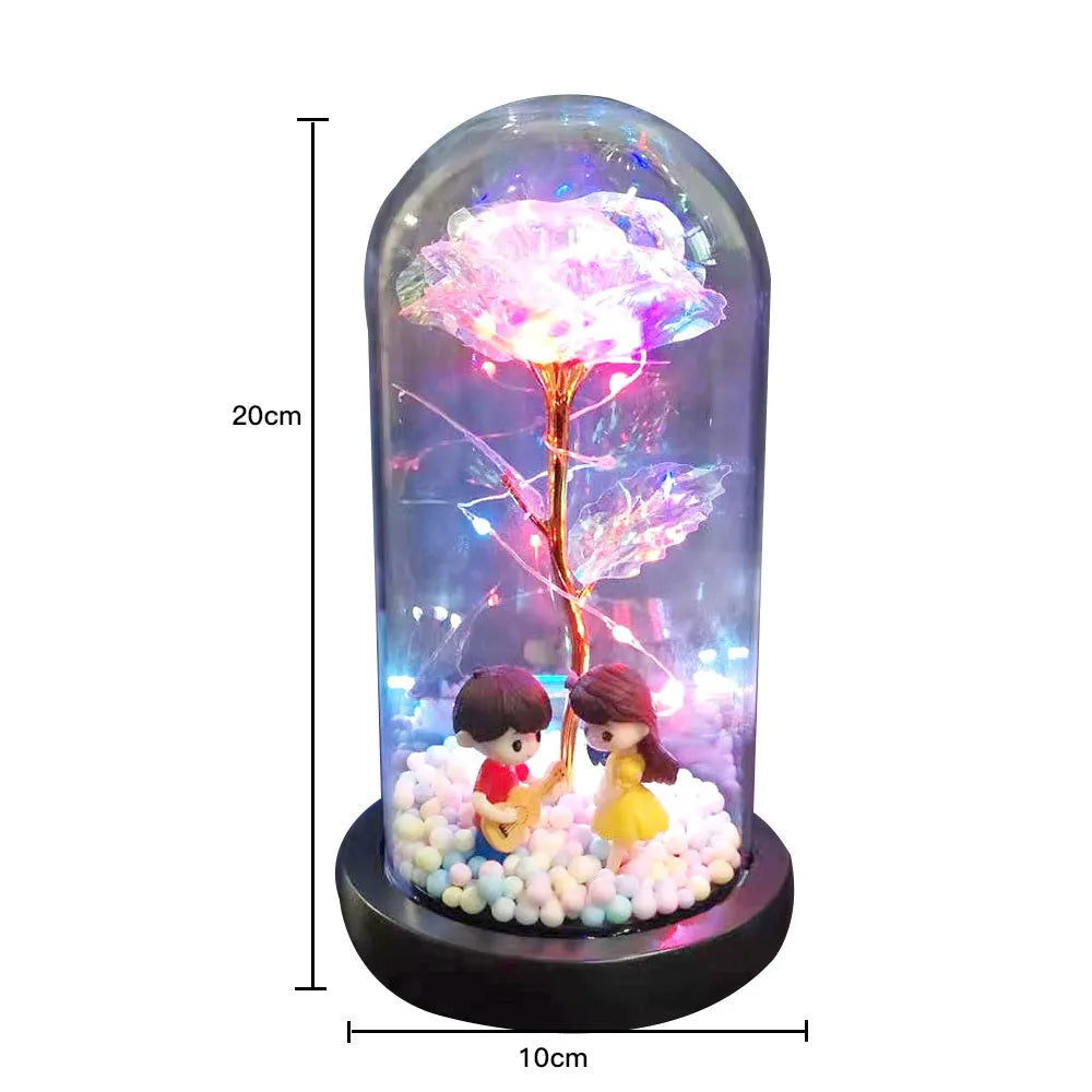 Artificial gold rose in glass flask with LED lights on black base, 20cm tall