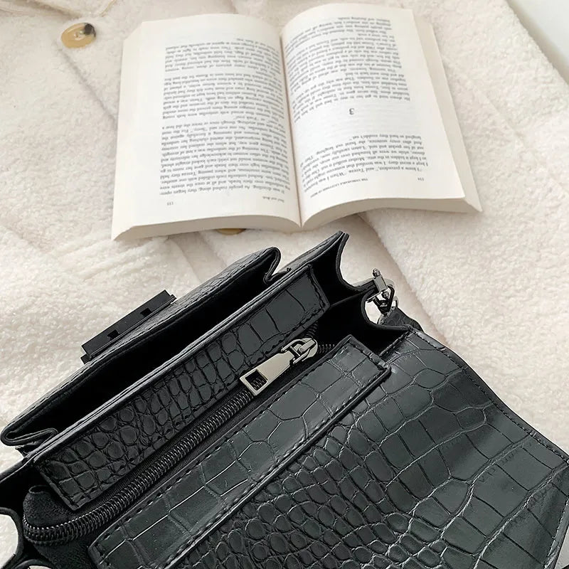 Vintage-style women's crossbody bag in PU leather, shown in black, with adjustable strap.