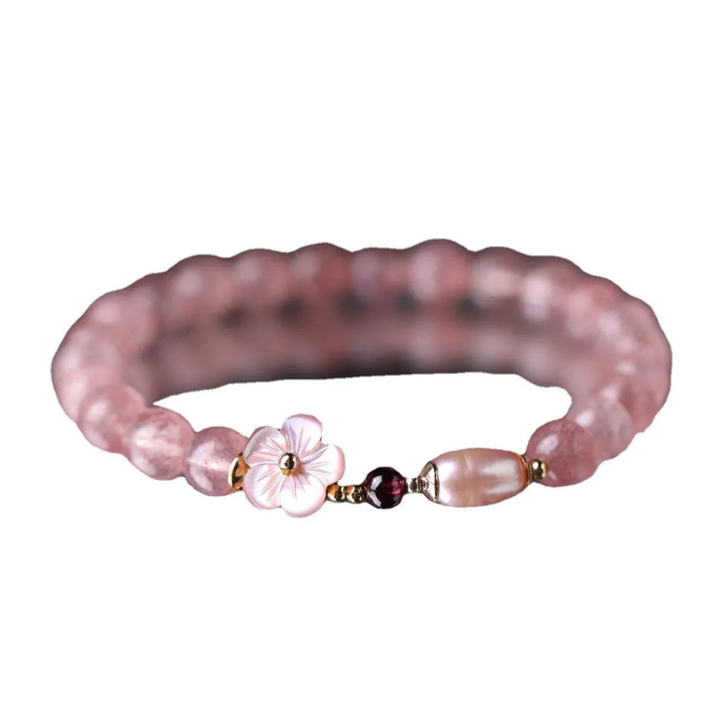 Women's strawberry quartz crystal bracelet with flower-shaped peach blossom design on wrist