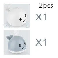 White and blue electric whale bath toy spraying water with lights on a base.