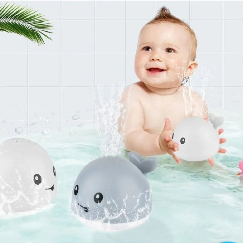 White and blue electric whale bath toy spraying water with lights on a base.