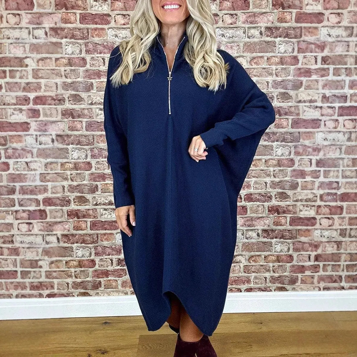Women's solid colour loose knitted dress with a zipper detail on a hanger.