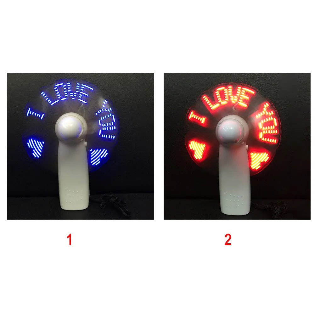 White handheld mini fan displaying blue and red LED 'I love you' pattern, shown next to a ruler for scale.