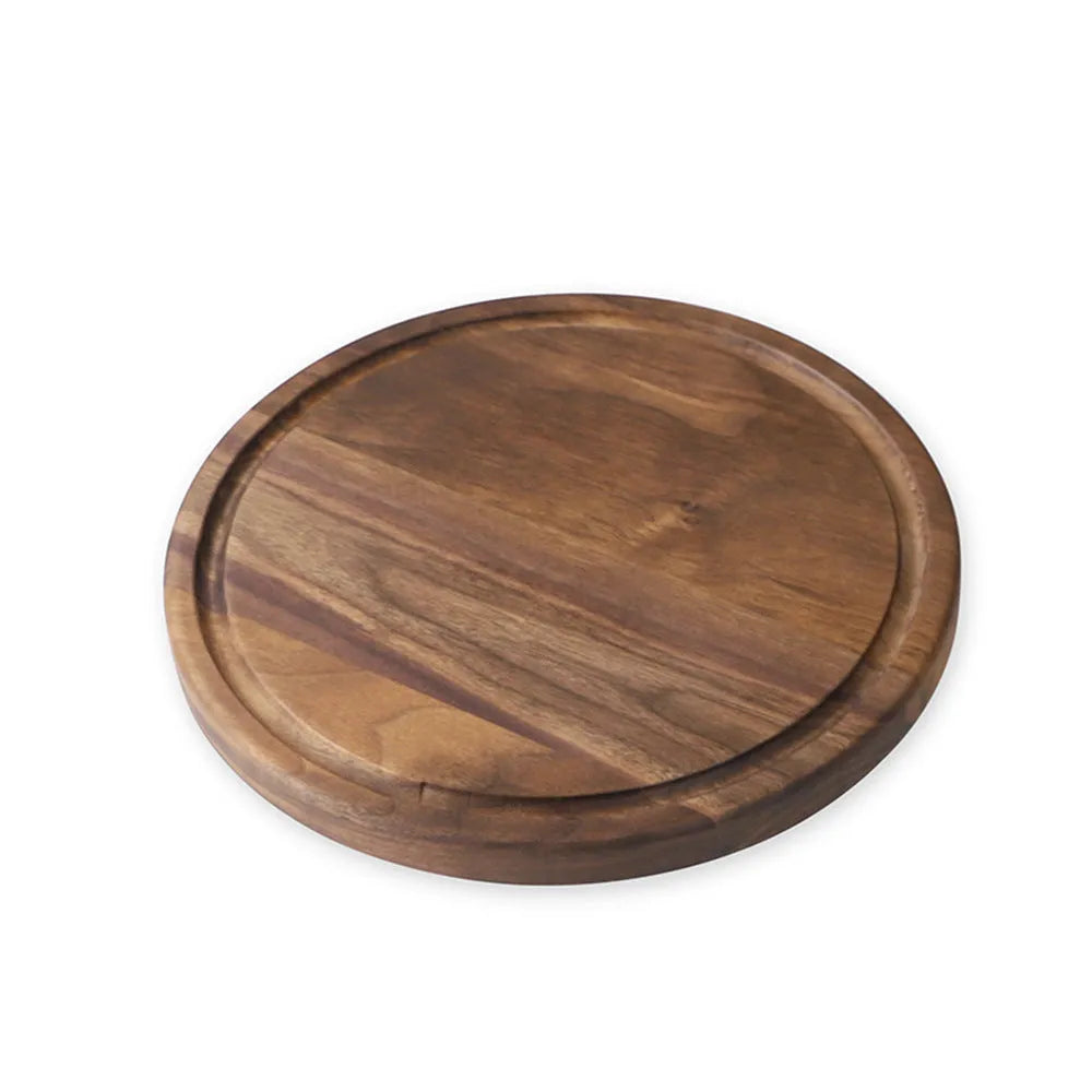 Black walnut wood double-sided cutting board with juice groove and side handle on kitchen counter
