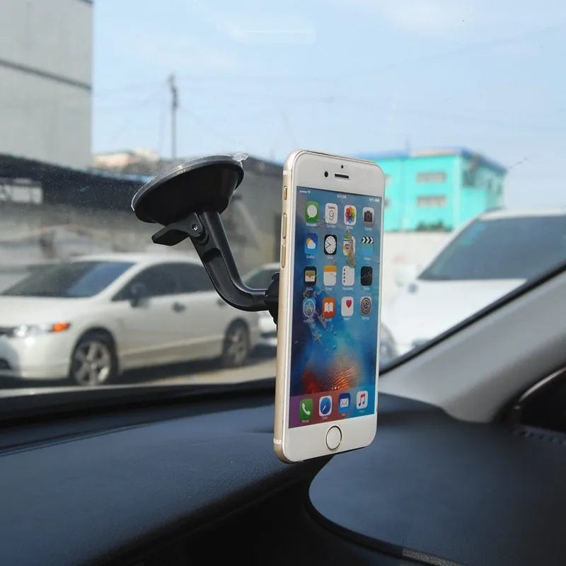 Black magnetic car phone holder with strong magnet mounted on dashboard, holding a smartphone in landscape mode