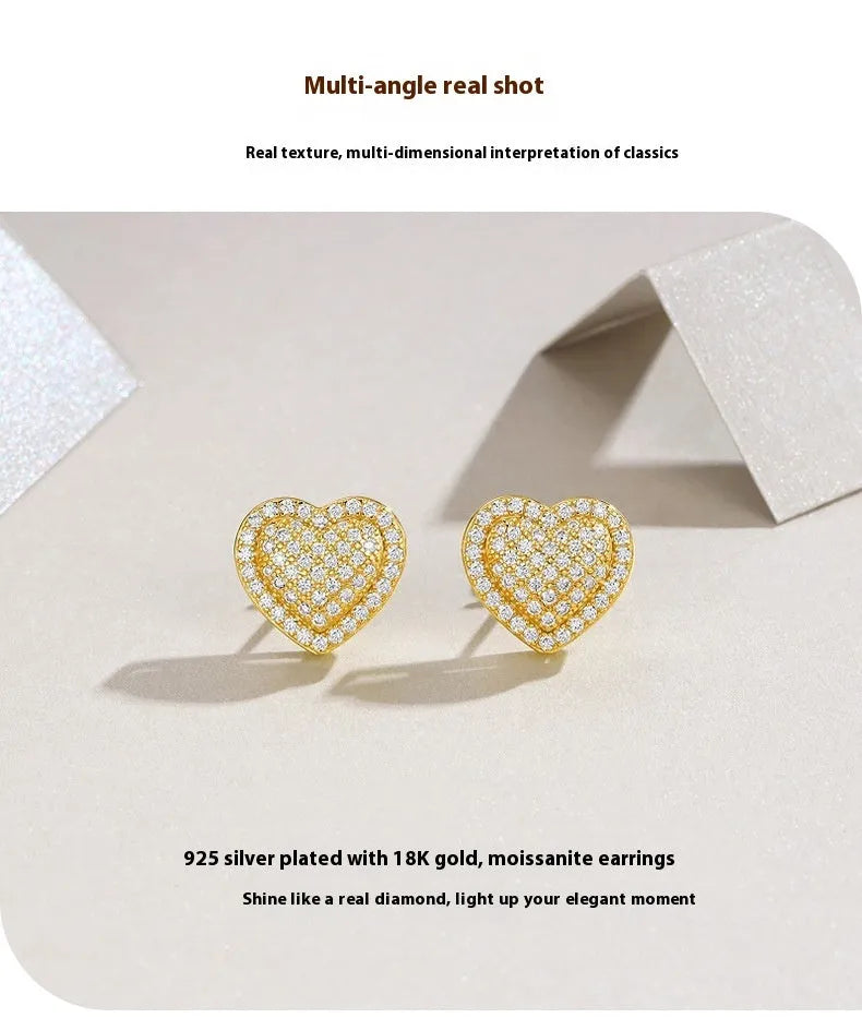 Gold-coloured heart-shaped moissanite stud earrings made from S925 silver on a plain background.