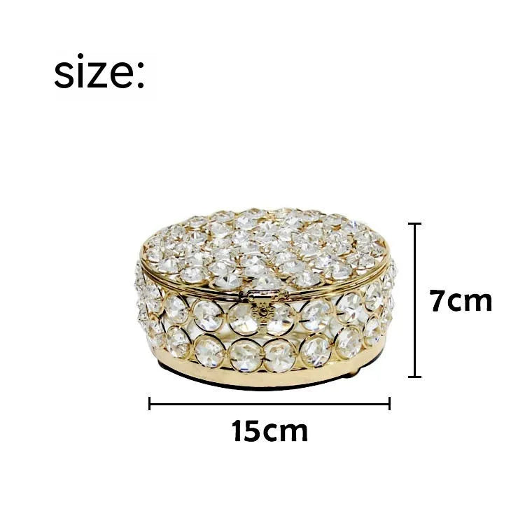 Clear crystal glass jewellery box with a French gold metal frame on a table.