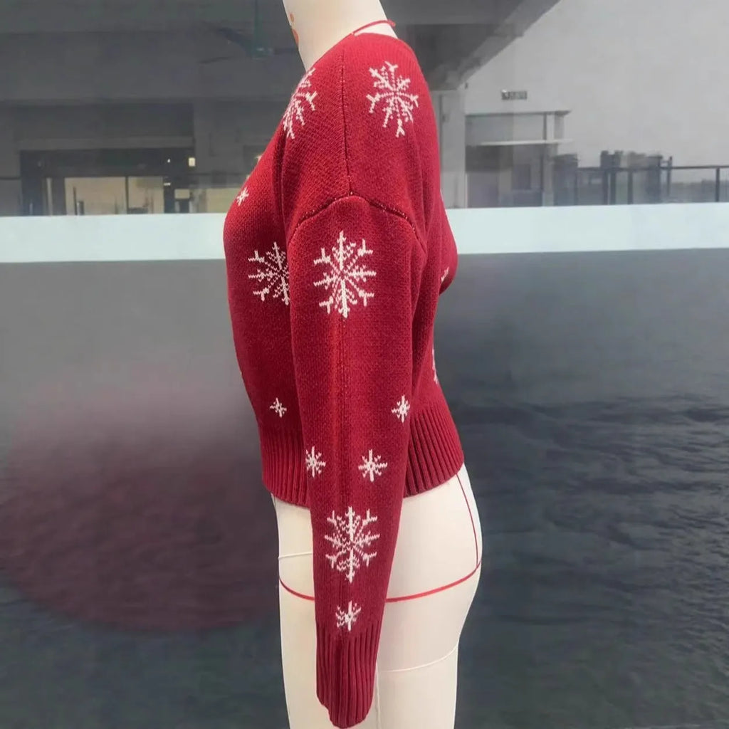 Women's red snowflake jacquard boat neck pullover sweater with long sleeves and crocheted flower details on a white background
