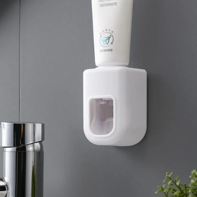 Automatic toothpaste dispenser wall-mounted in blue, with push button and toothpaste nozzle, 9 x 6 x 6 cm