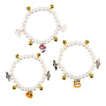 Three pearl necklaces with bells for pets laid out for Halloween costume decoration