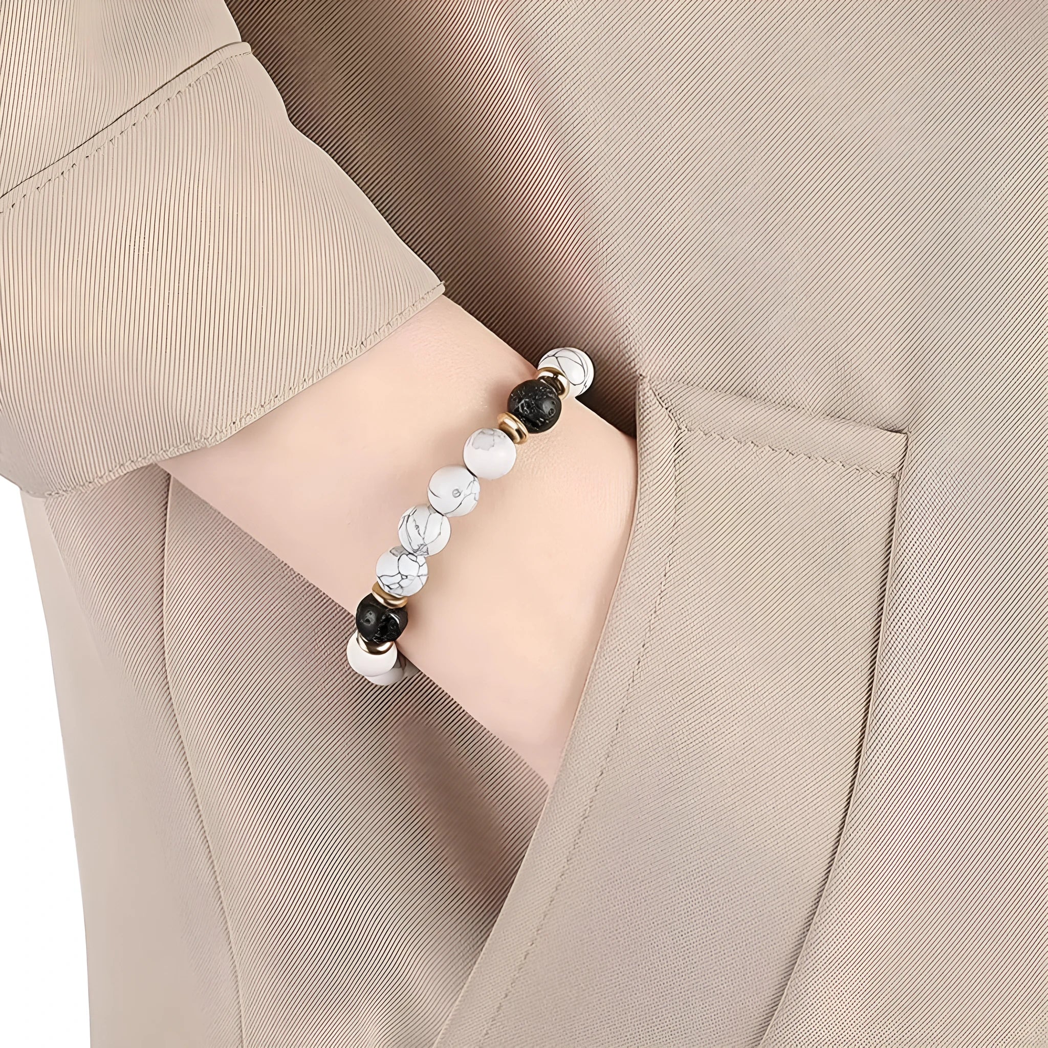 Handmade natural stone bracelet with alloy volcano and white turquoise beads on neutral background