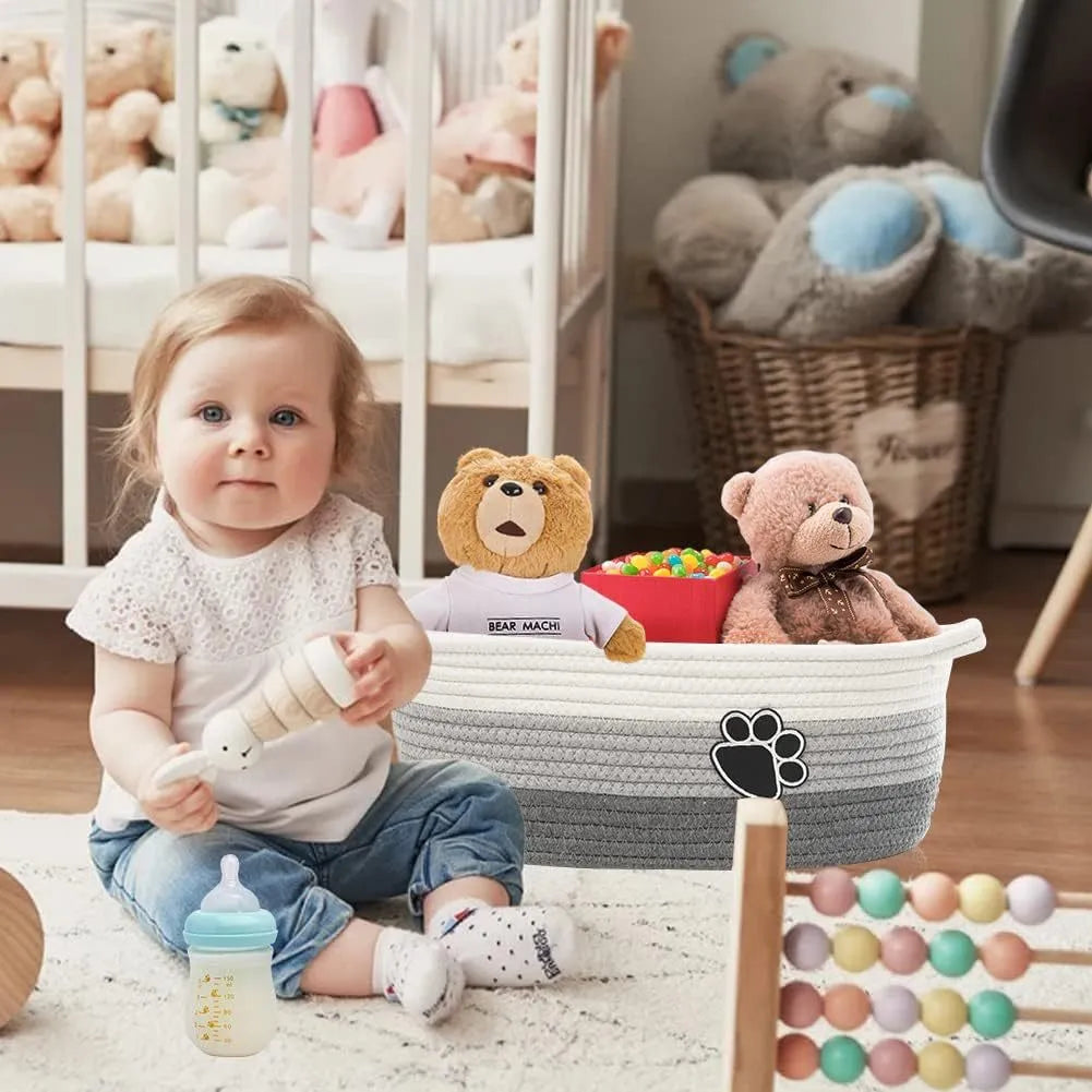 Small light beige woven cotton rope storage basket with handles on a wooden surface.