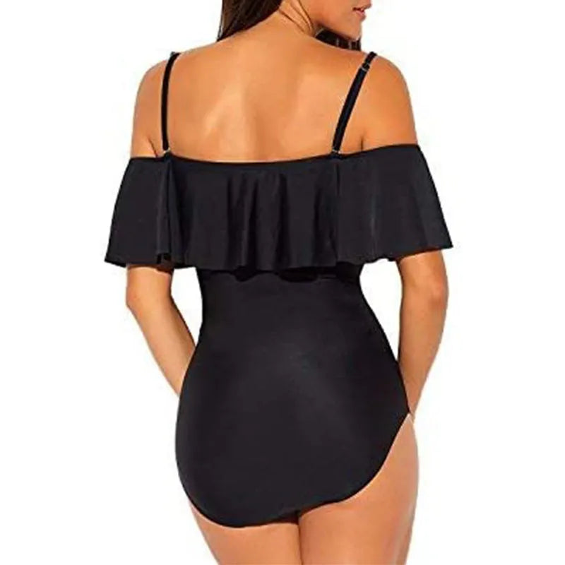 Black one-piece swimsuit with cut-out design and ruffled straps on a tube top.