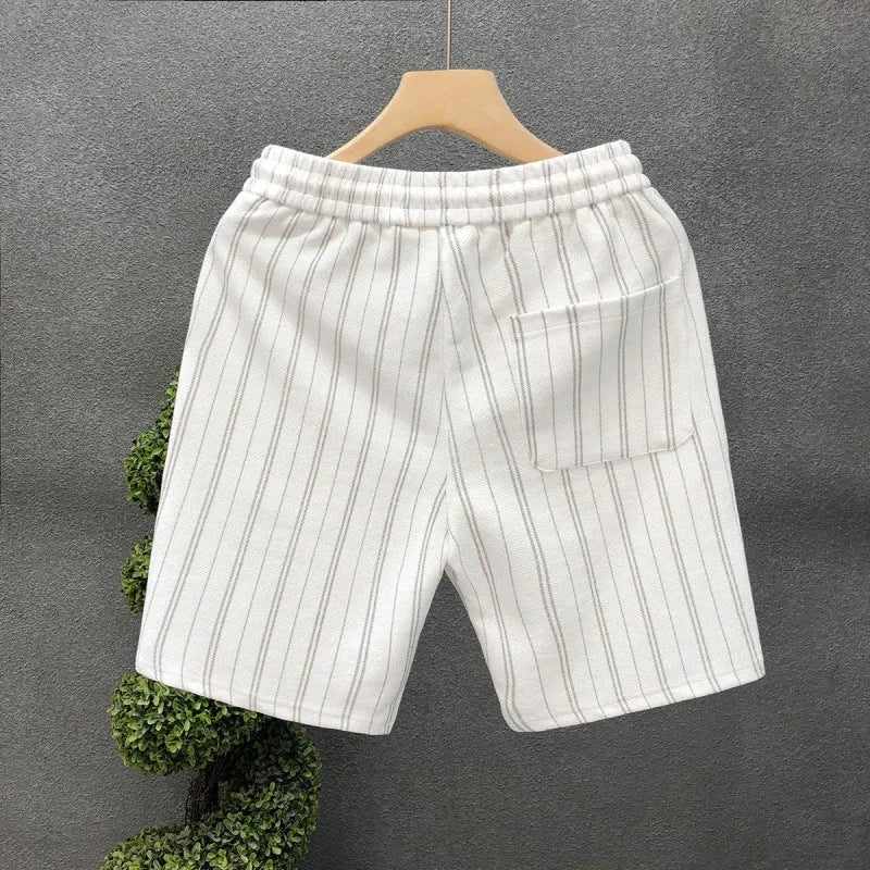 Man wearing black and white striped fleece-lined casual shorts with an elastic waistband.