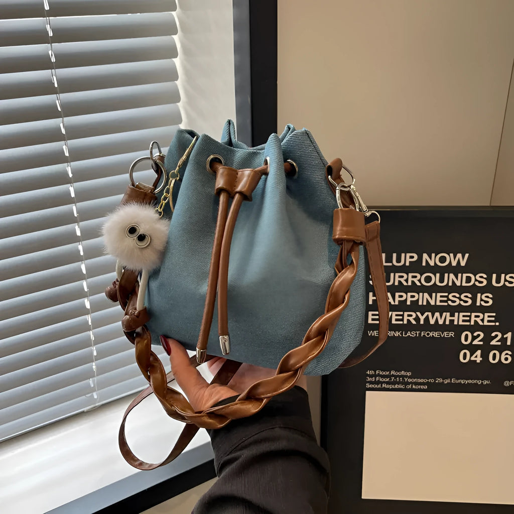 Blue synthetic leather cross body bucket bag with one-shoulder strap and sandwich pocket design
