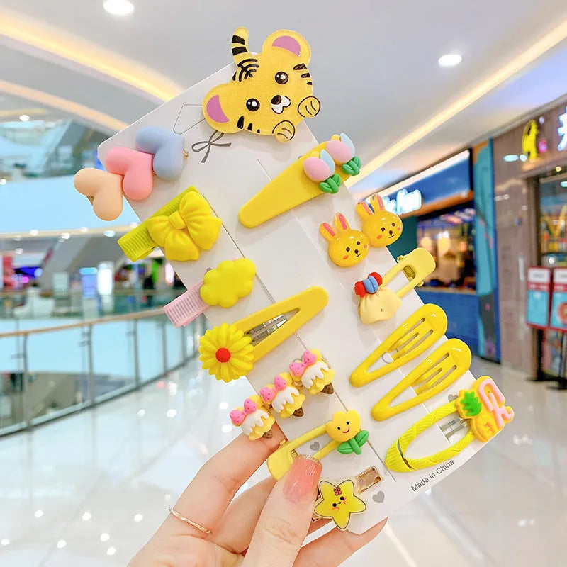 14-piece toddler hair accessories set on display including rainbow barrettes, fruit clips, and butterfly pins in bright colours