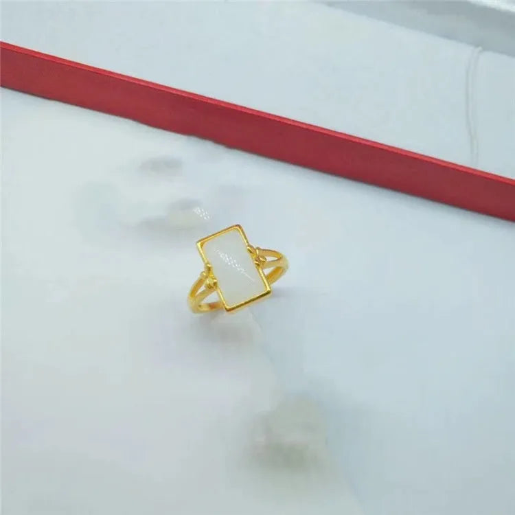 Adjustable brass gold-plated ring with electroplated finish and a coloured gemstone.