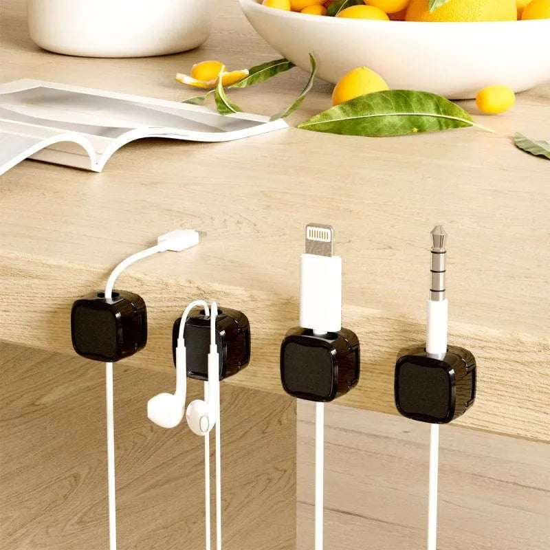 White and black cable clips holding under desk wires including USB and HDMI cables