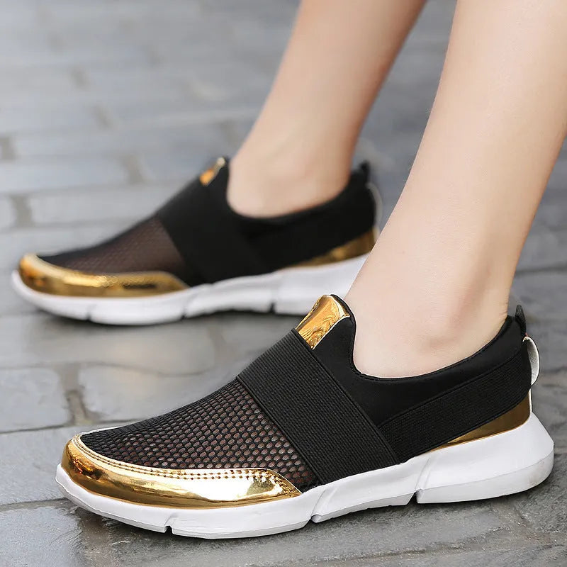 Blue low-top women's mesh sneakers with a casual design on a hard floor surface.