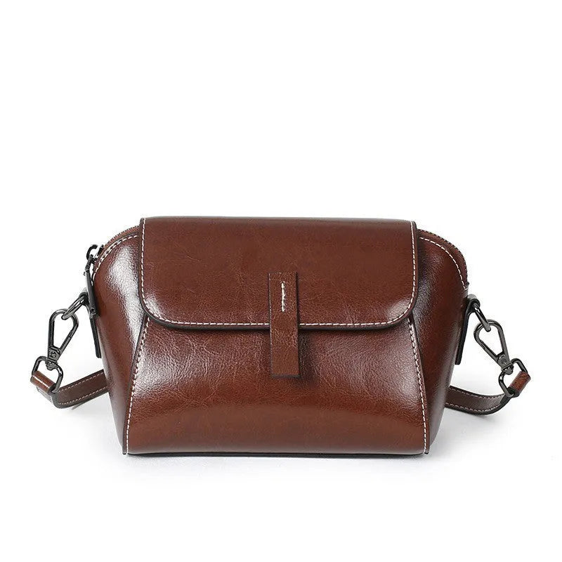 Women's brown shell-shaped messenger bag in oil wax leather with cross-body strap and organised interior