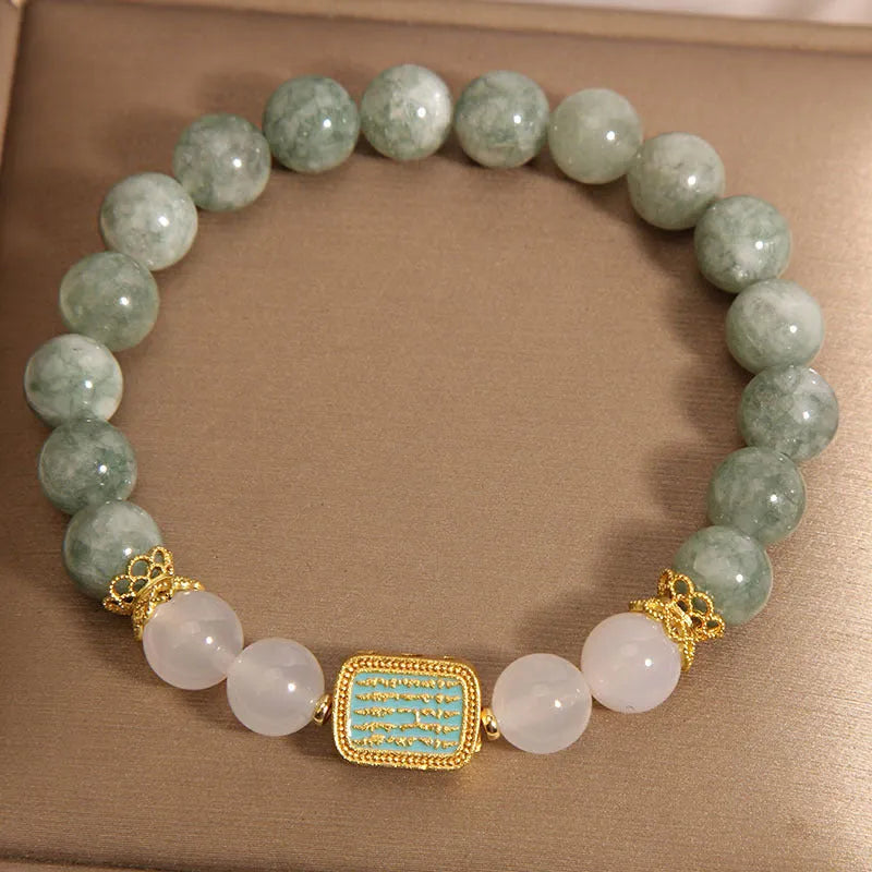 Women's oil green emerald crystal bracelet with five scripture pieces on a wrist.