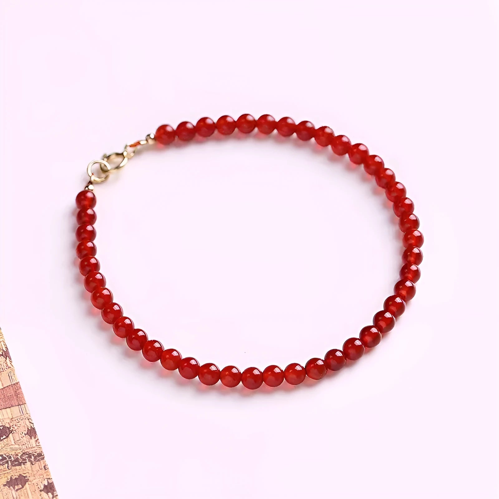 Ultra-thin red agate small bracelet for women, classic style, on a plain background.
