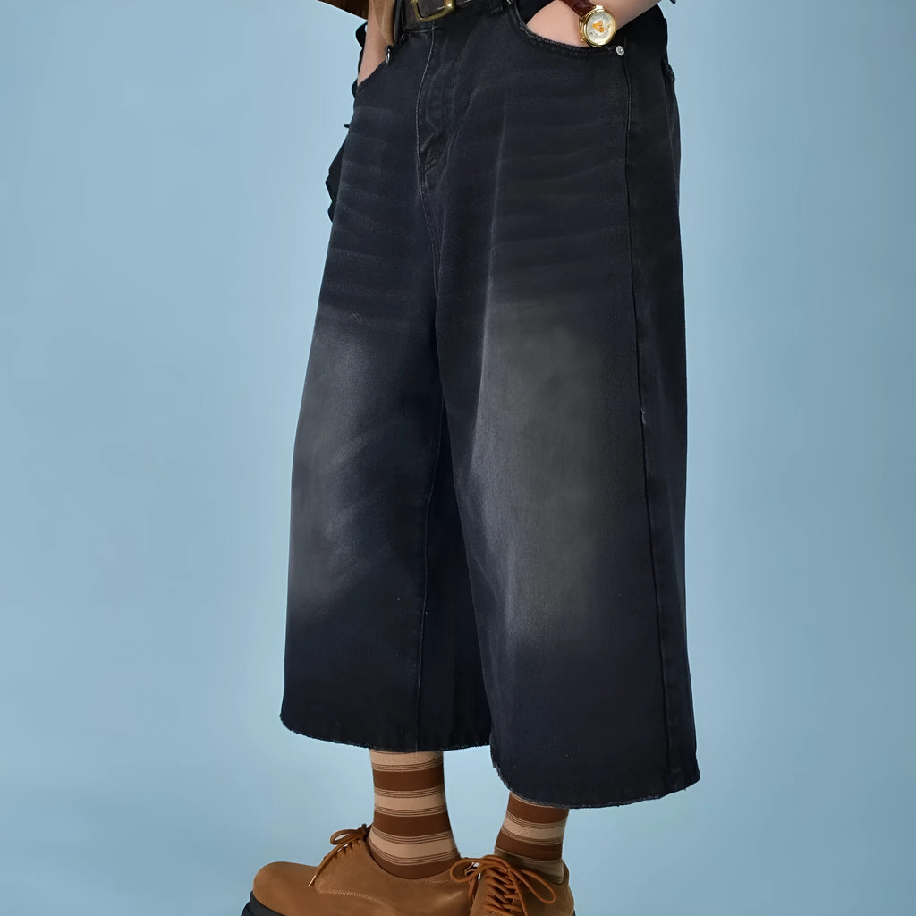 Men's loose straight-cut denim shorts in blue shown on a model, featuring a fifth-pants length.
