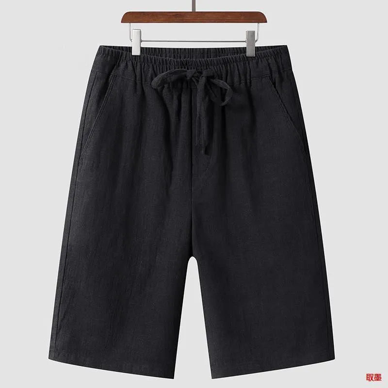 Man wearing beige linen shorts with a loose cropped fit and elasticated mid waist.