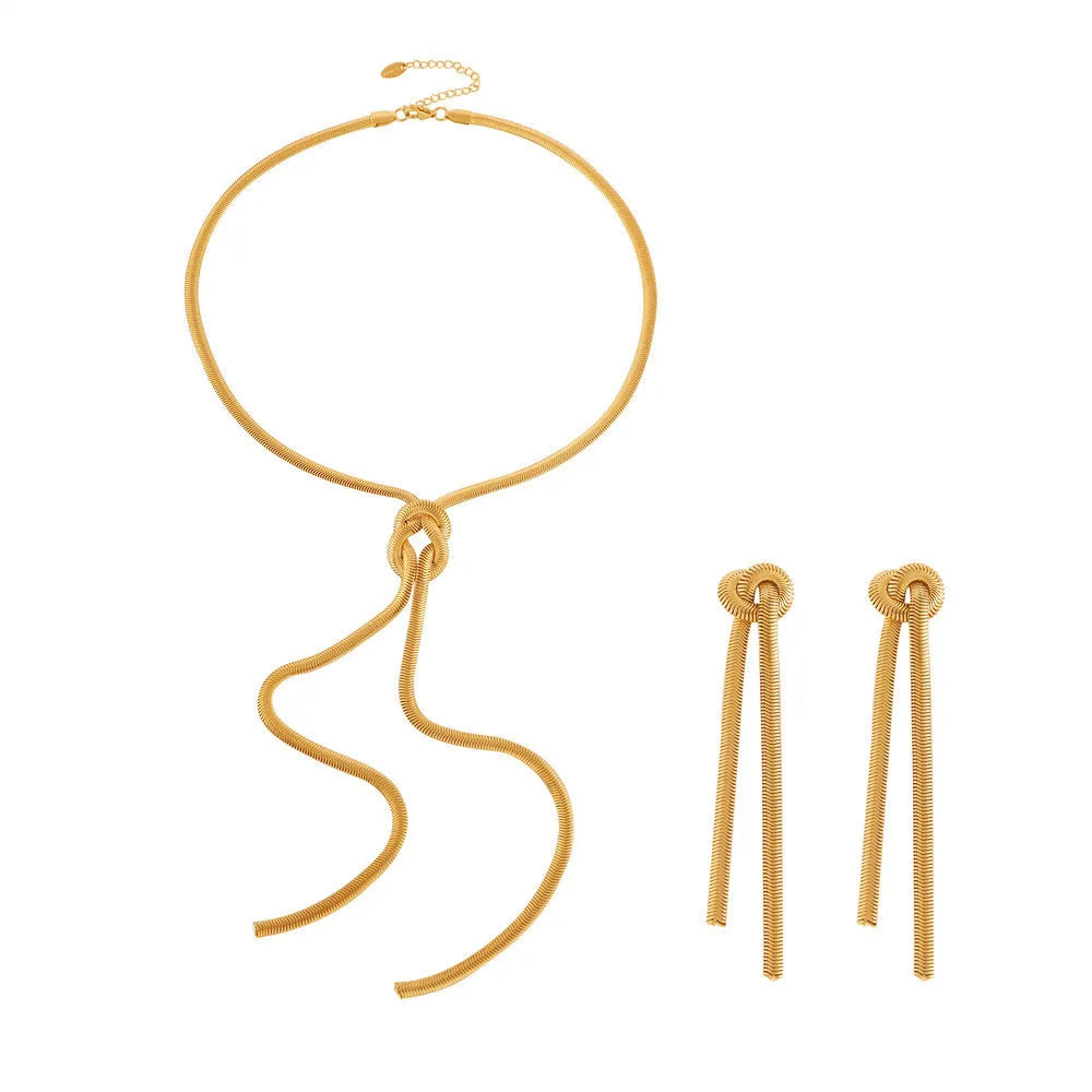 Gold knotted tassel snake chain long necklace with matching earrings on white background