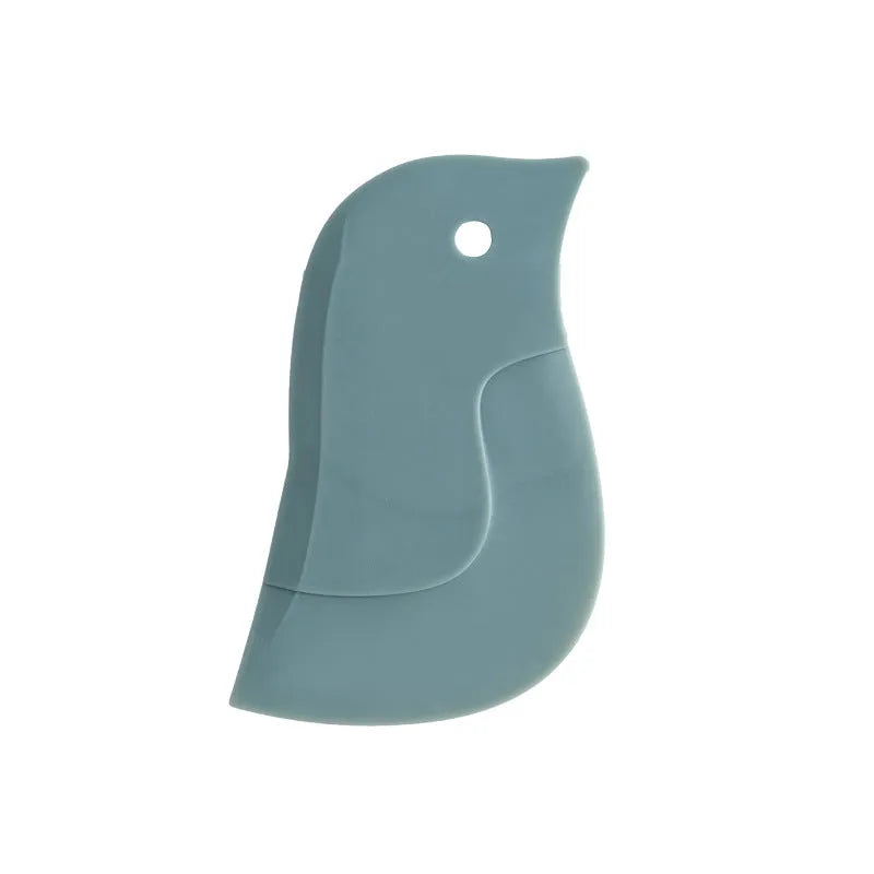 Penguin shape soft blade scraper 11x7cm in green cleaning a plate with sauce residue