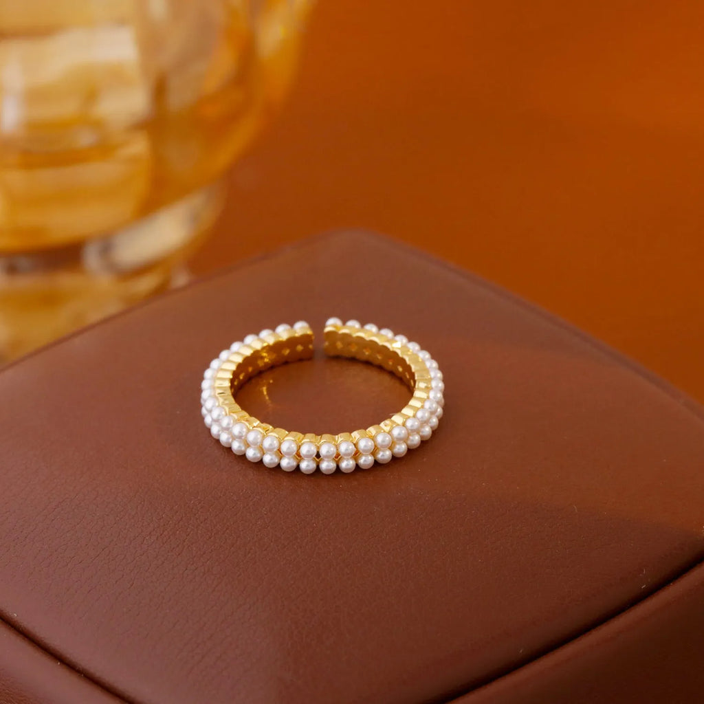 Gold geometric open mouth ring with pearl detail on female hand