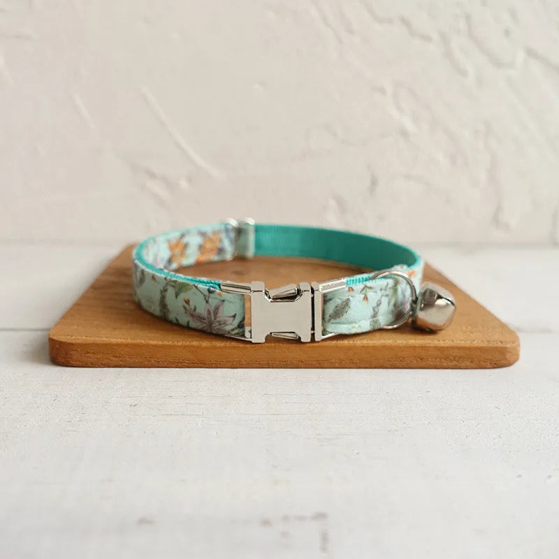 Green adjustable pet collar made of cloth and webbing on a neutral background