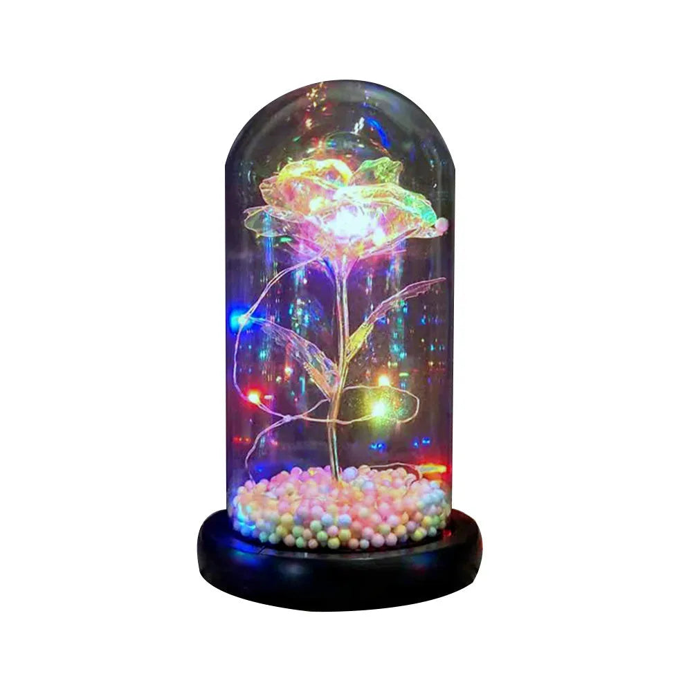 Artificial gold rose in glass flask with LED lights on black base, 20cm tall