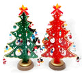 Set of three hand-painted wooden Christmas trees in green and red, 36cm tall, on a table
