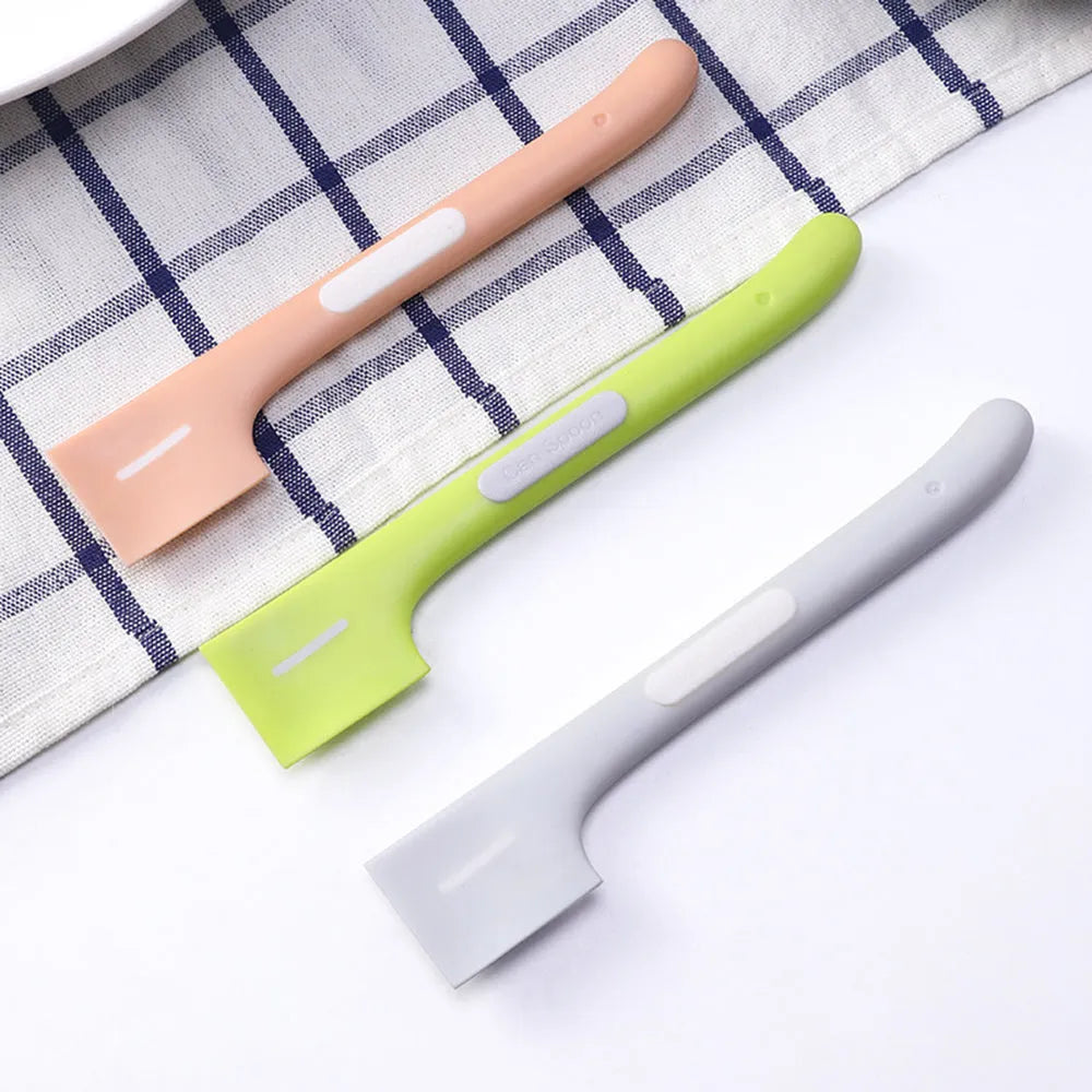 Green long-handled TPR spoon for scooping pet canned food on a white background