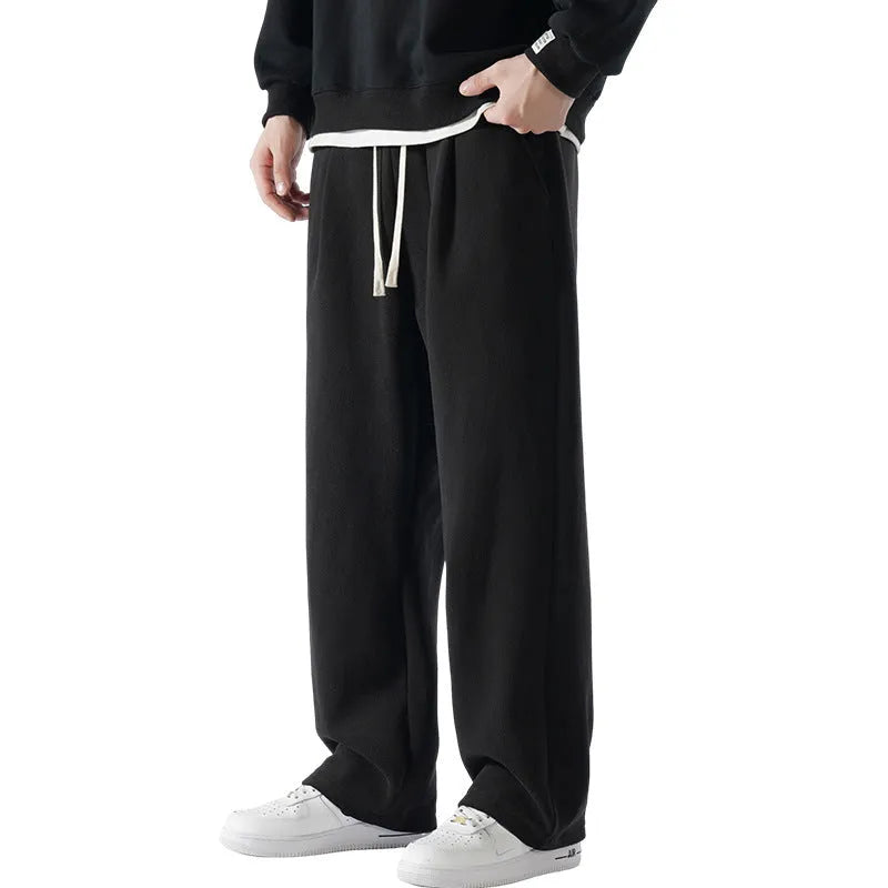 Men's apricot double-sided polar fleece winter trousers with a loose fit and drawstring waistband on a hanger.