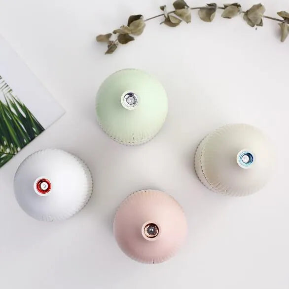 White ultrasonic aromatherapy diffuser with LED lights showing water mist emission