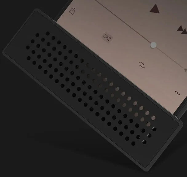 A small, coloured plastic mobile phone amplifier bracket holding an iPhone on a desktop.