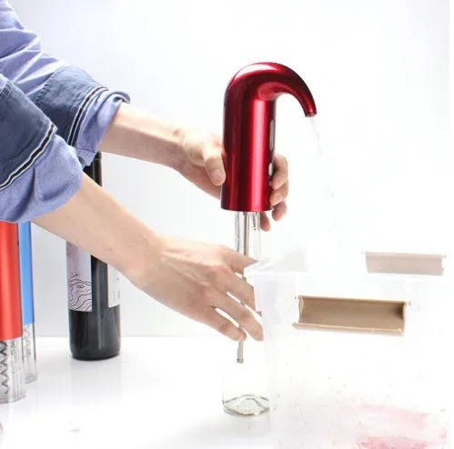 Portable electric wine decanter in black with red light, ABS and silicone body, on a table next to a wine glass