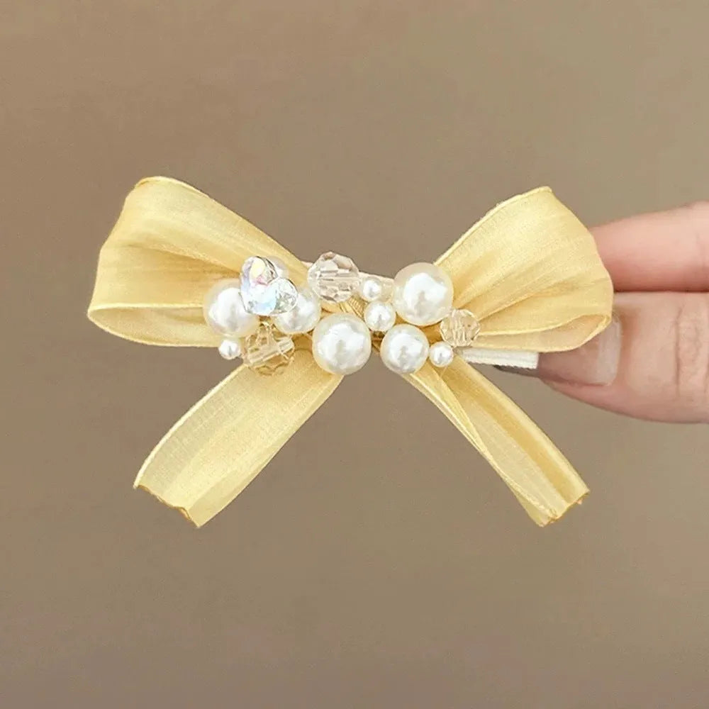 Yellow bow barrette with rhinestone and pearl on plastic duckbill clip for women