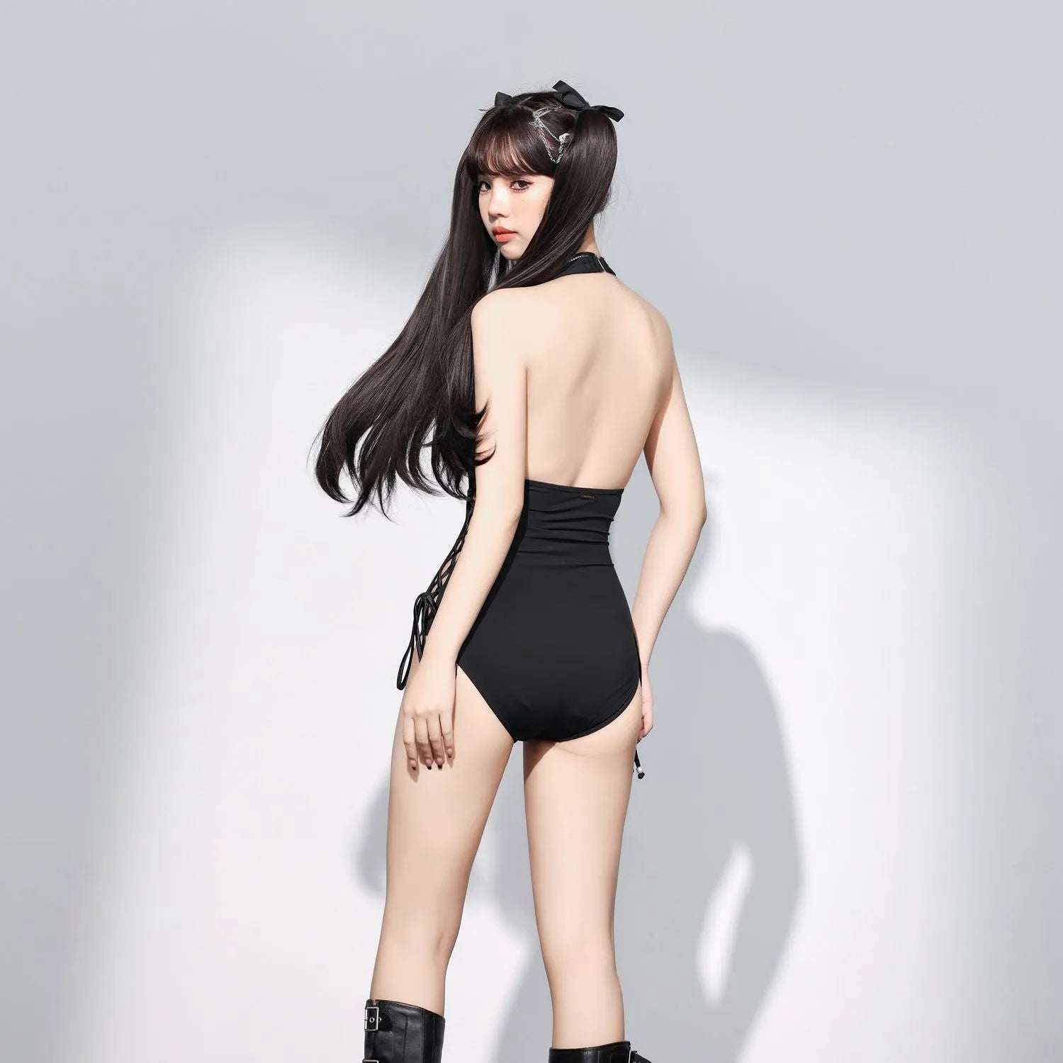 Women's black V-neck hollow strap niche one-piece swimsuit on plain background