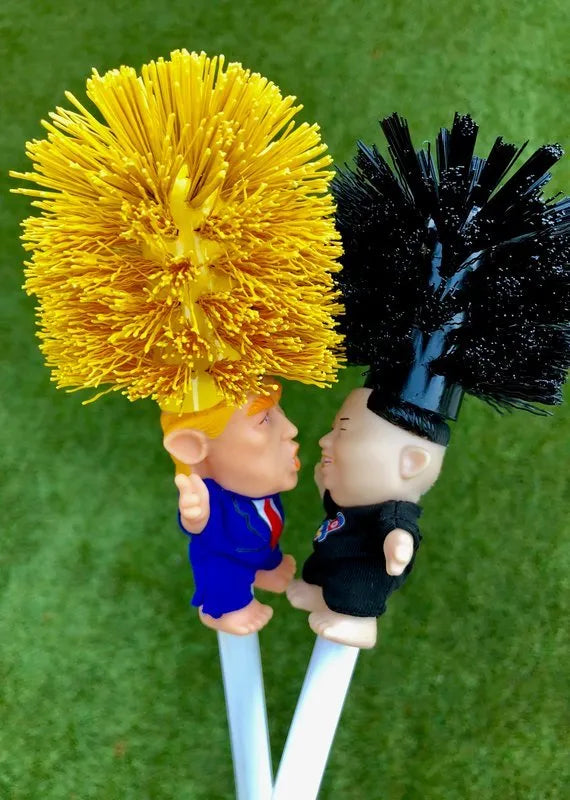 Yellow plastic Donald Trump toilet brush with handle slot, 40cm length, on white background