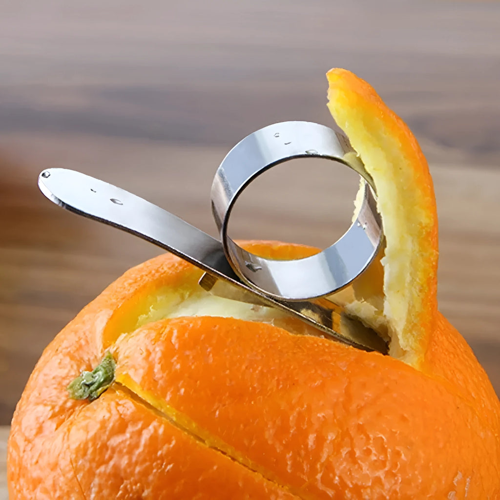 Silver stainless steel ring peeler for citrus fruits on a white background