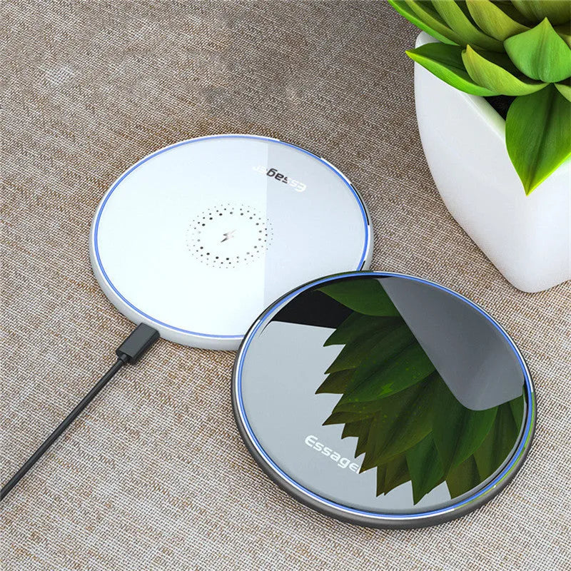 Black or white 15W Qi wireless charging pad on a table with LED light and phone charging.