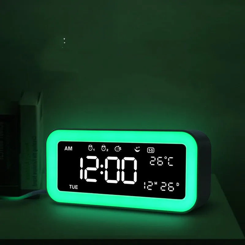Blue rectangular LED atmosphere light alarm clock with digital display on a wooden desk.