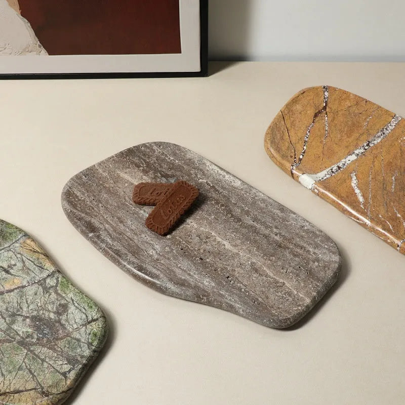 Irregular natural marble tray in coffee colour on a wooden coffee table with decorative objects