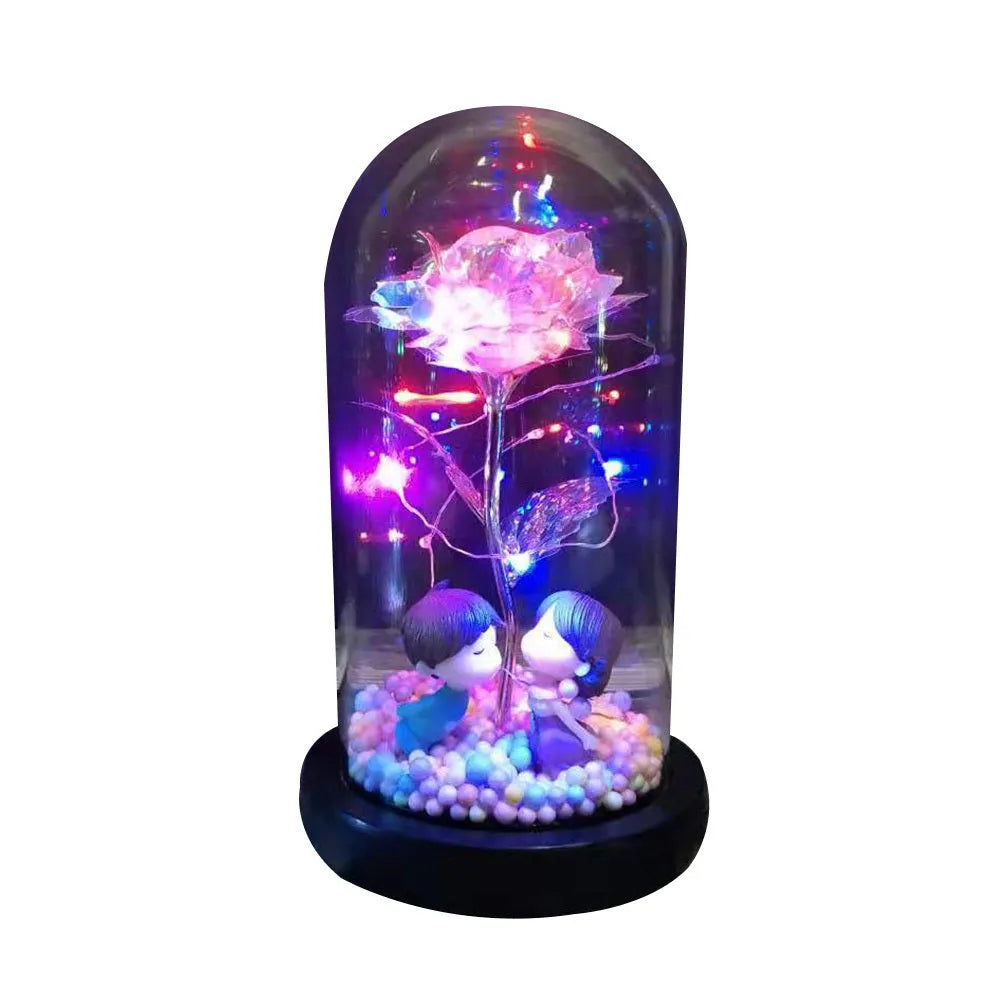 Artificial gold rose in glass flask with LED lights on black base, 20cm tall