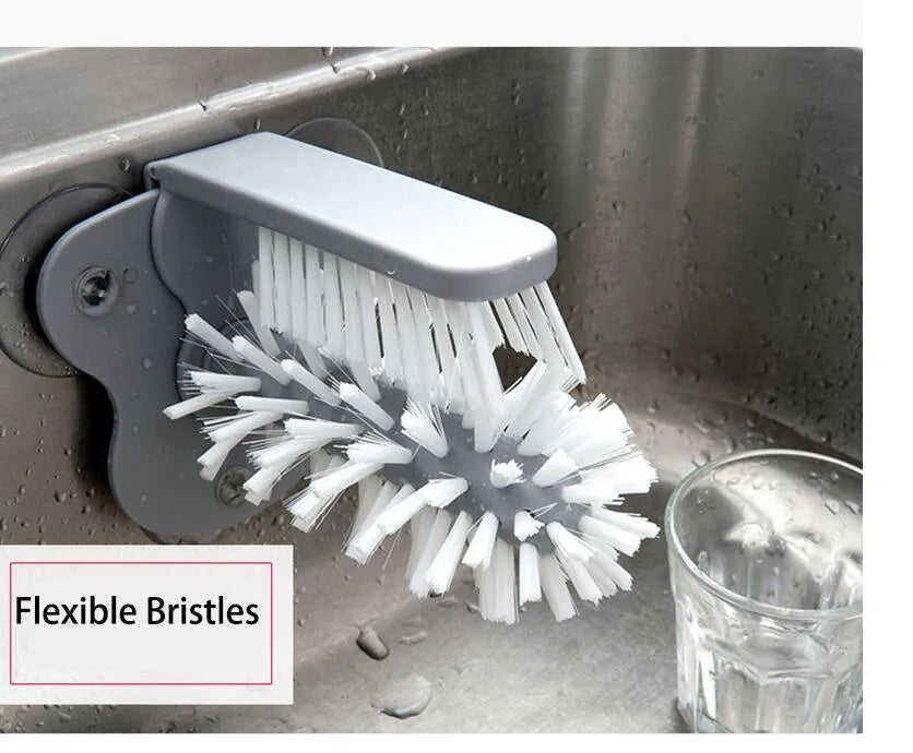 Grey suction cup brush with double-head design and two suction cups on a kitchen wall