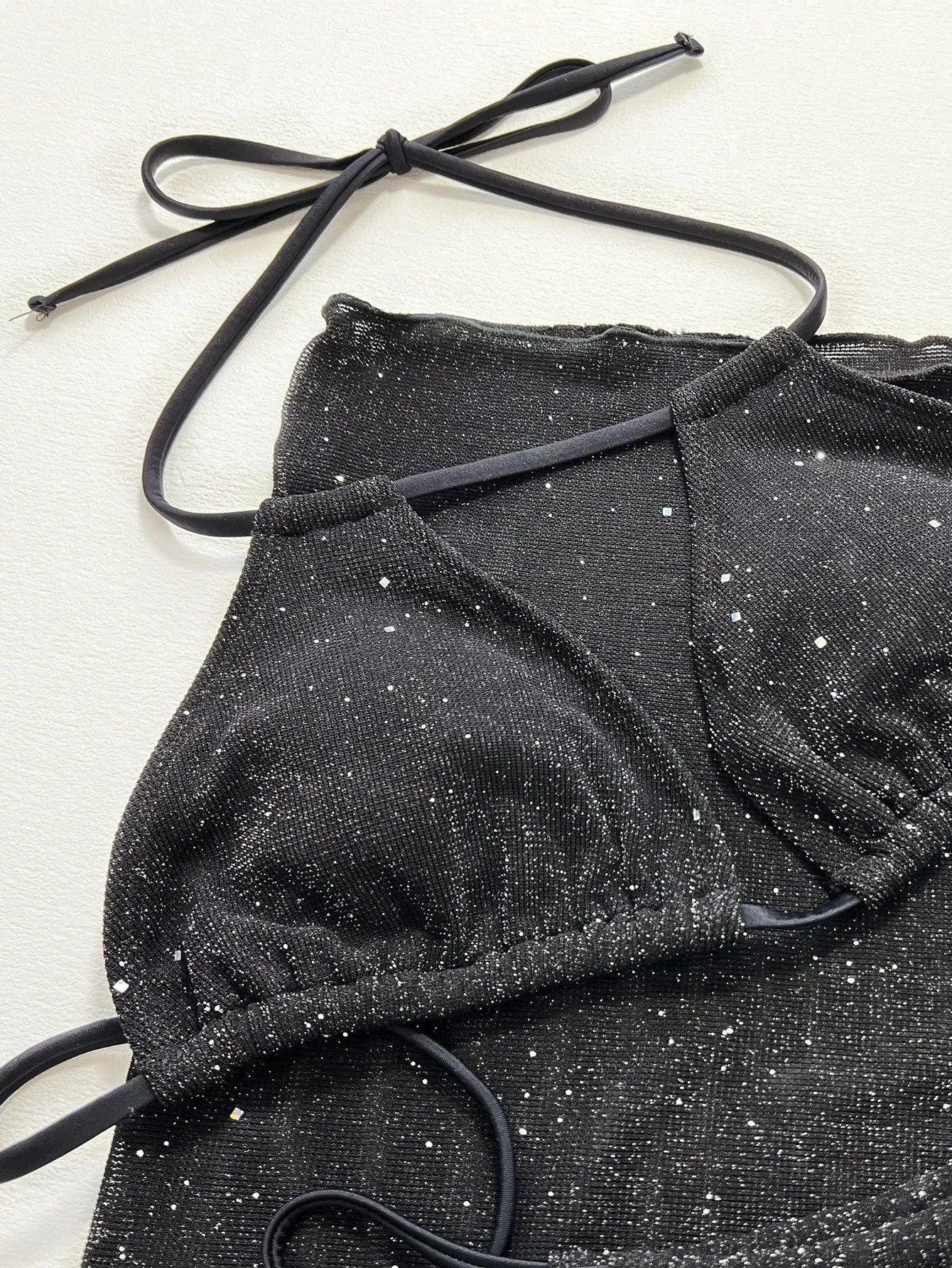 Black three-piece women's bikini swimsuit with separate top and shorts